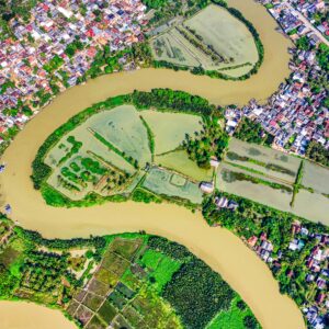 Vibrant aerial view of a river bending through lush farmland and a rural town.